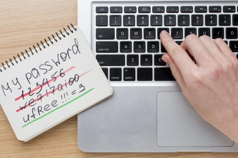 Flat lay laptop with hands notebook with password information